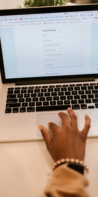 Close-Up Shot of a Person Filling out a Form Using a Laptop