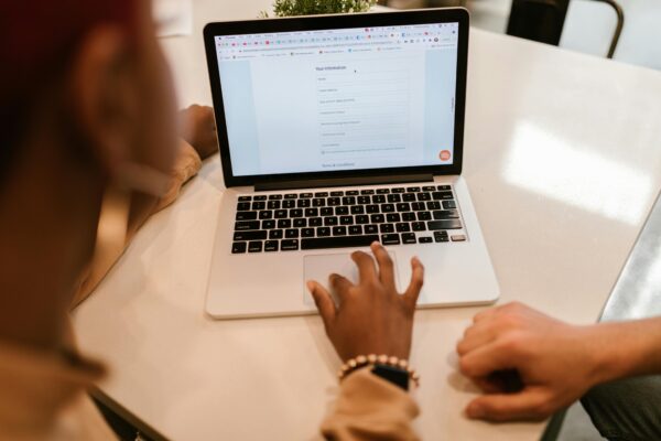 Close-Up Shot of a Person Filling out a Form Using a Laptop