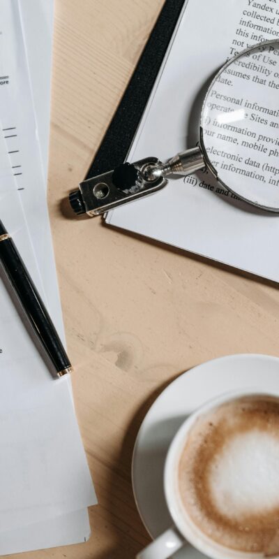 Coffee, Pen and Magnifying Glass on Papers