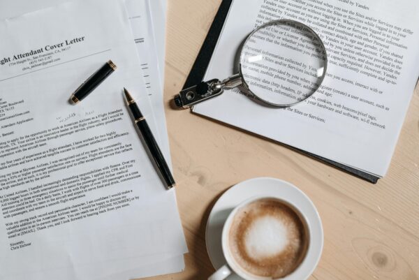 Coffee, Pen and Magnifying Glass on Papers